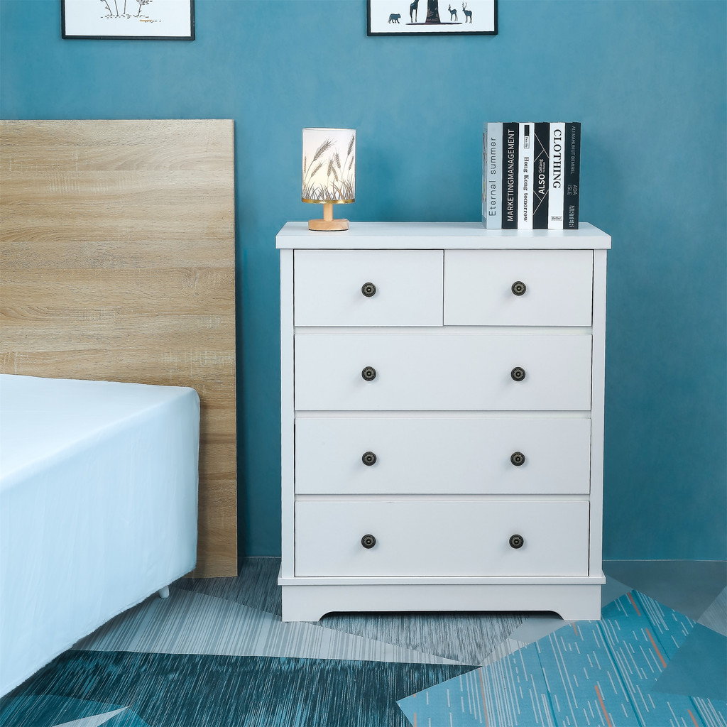 White dresser next to bed with books on top